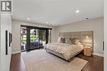 Niagara-On-The-Lake apartment for rent - A bedroom with a large bed and a sliding glass door.