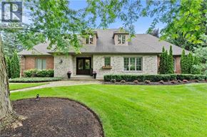 Niagara-On-The-Lake apartment for rent - A house with a well-manicured lawn and a tree in front.