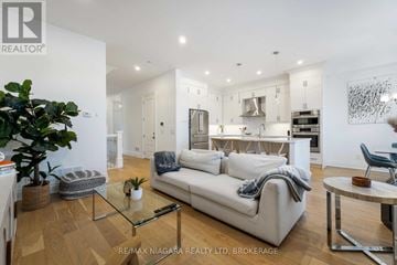 St. Catharines (Glendale/Glenridge) townhouse for rent - A modern living room with a glass coffee table and a white sofa.