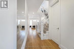 St. Catharines (Glendale/Glenridge) townhouse for rent - A hallway with a staircase and a white door.