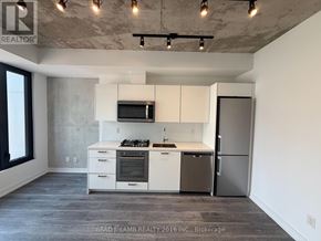 Toronto (Moss Park) condo for rent - A kitchen with white cabinets and a stainless steel refrigerator.