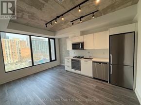 Toronto (Moss Park) condo for rent - A well-lit kitchen with stainless steel appliances and a view of the city.