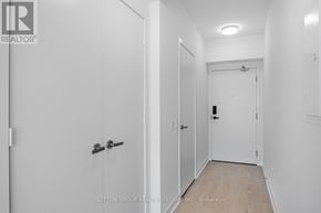 Mississauga (City Centre) condo for rent - A hallway with white walls and a wooden floor.