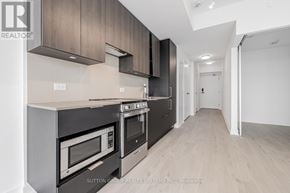 Mississauga (City Centre) condo for rent - A modern kitchen with stainless steel appliances and wooden cabinets.