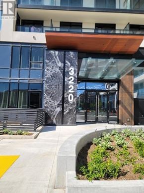 Oakville (Oa Rural Oakville) condo for rent - A modern building with a glass facade and a wooden overhang.