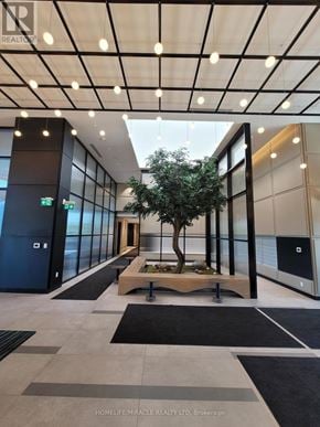 Oakville (Oa Rural Oakville) condo for rent - A tree in a planter sits in the middle of a hallway.