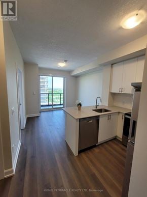 Oakville (Oa Rural Oakville) condo for rent - A kitchen with white cabinets and a wooden floor.
