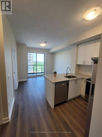 Oakville (Oa Rural Oakville) condo for rent - A kitchen with white cabinets and a wooden floor.