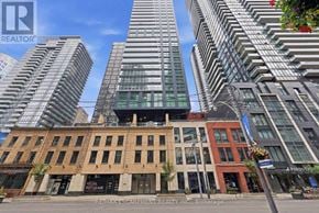 Toronto (Waterfront Communities) condo for rent - A building with a sign that says REALTOR in front of a tall building.