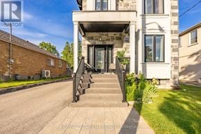 Toronto (Clairlea-Birchmount) apartment for rent - A house with a front yard and a driveway leading to the front door.