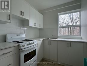Hamilton (Corktown) multi-family for rent - A white stove and sink in a white kitchen.