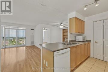 Mississauga (Hurontario) condo for rent - A kitchen with wooden cabinets and a white dishwasher.