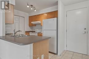 Mississauga (Hurontario) condo for rent - A kitchen with a white fridge, sink and cabinets.