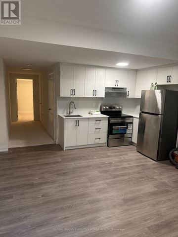 Oakville (Oa Rural Oakville) apartment for rent - A kitchen with white cabinets and a refrigerator.