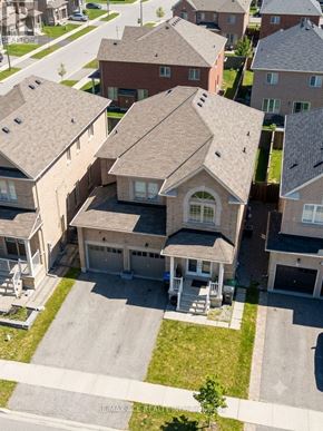Brampton (Bram East) apartment for rent - A large house with a garage is in the foreground of a neighborhood.
