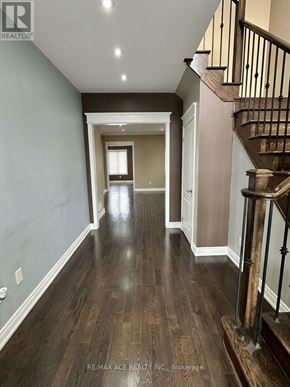 Brampton (Bram East) apartment for rent - A hallway with a staircase and wood flooring.