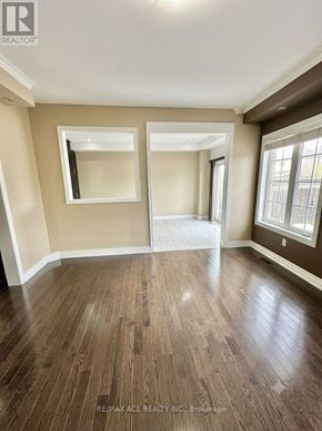 Brampton (Bram East) apartment for rent - A room with wood flooring and a large mirror on the wall.