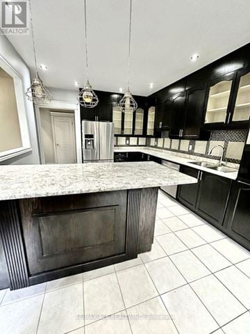 Brampton (Bram East) apartment for rent - A kitchen with a marble countertop and black cabinets.