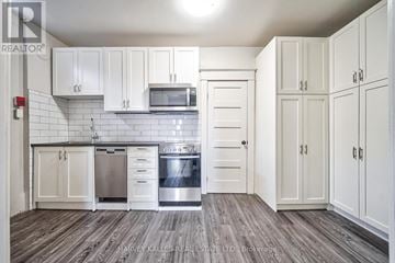 Toronto (Oakwood Village) multi-family for rent - A kitchen with white cabinets and a stainless steel dishwasher.
