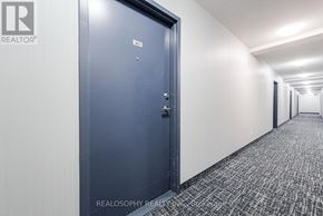 Toronto (Clairlea-Birchmount) condo for rent - A hallway with a blue door and a Realty logo on the wall.