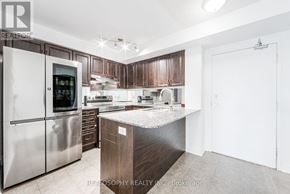Toronto (Clairlea-Birchmount) condo for rent - A modern kitchen with a stainless steel refrigerator and wooden cabinets.