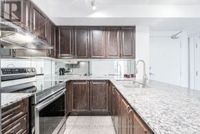 Toronto (Clairlea-Birchmount) condo for rent - A kitchen with dark wood cabinets and a white marble countertop.