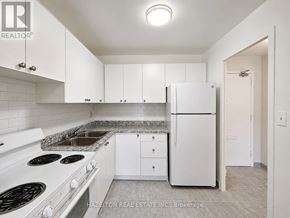 Mississauga (Applewood) condo for rent - A kitchen with white cabinets and a white fridge.