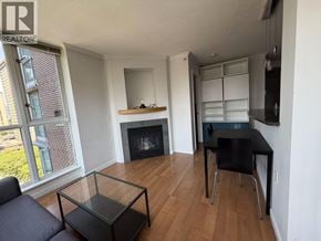 Vancouver apartment for rent - A living room with a fireplace and a dining table.