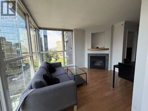 Vancouver apartment for rent - A living room with a grey couch and a fireplace.
