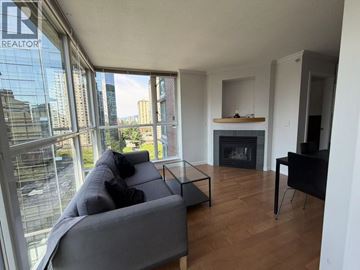 Vancouver apartment for rent - A living room with a grey couch and a fireplace.