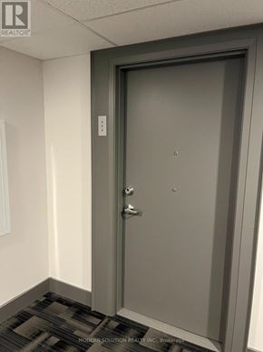 Guelph (Grange Road) condo for rent - A grey door with a handle and a key slot.