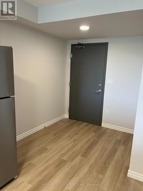 Guelph (Grange Road) condo for rent - A room with a wooden floor and a black door.