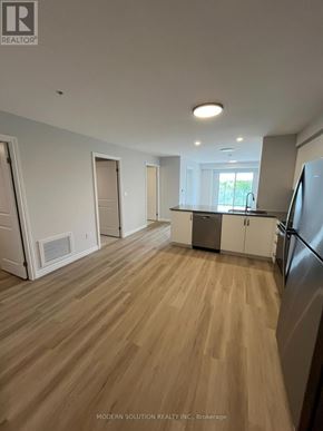 Guelph (Grange Road) condo for rent - A spacious kitchen with wooden flooring and white walls.