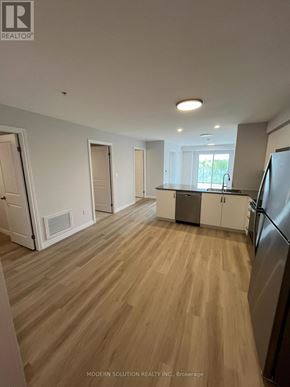 Guelph (Grange Road) condo for rent - A kitchen with a refrigerator, cabinets, and a window.
