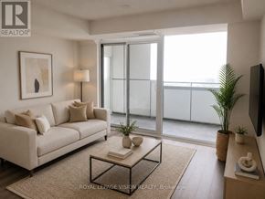Toronto (Waterfront Communities) condo for rent - A living room with a white couch, a glass table, and a flat screen TV.