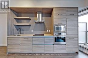 Toronto (Mount Pleasant West) condo for rent - A modern kitchen with wooden cabinets and a stainless steel oven.