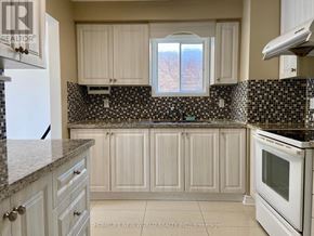 Markham (Markville) apartment for rent - A kitchen with white cabinets and a black and white checkered backsplash.