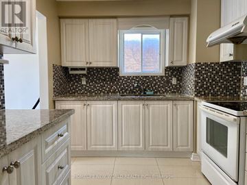 Markham (Markville) apartment for rent - A kitchen with white cabinets and a black and white checkered backsplash.