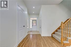 Mississauga apartment for rent - A hallway with wooden floors and white walls leading to a staircase.