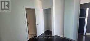Toronto (Bay Street Corridor) condo for rent - A hallway with a door on the left and a mirror on the right.