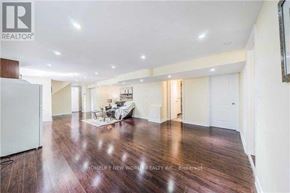 Toronto (Bayview Woods-Steeles) apartment for rent - A spacious living room with wooden floors and white walls.