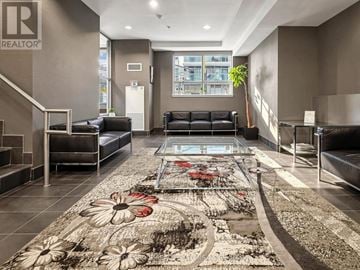 Toronto (Dovercourt-Wallace Emerson-Junction) condo for rent - A living room with a glass coffee table and a rug with flowers on it.