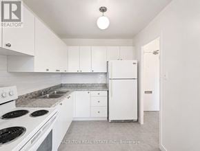 Mississauga (Applewood) condo for rent - A white kitchen with a stove top oven and a refrigerator.
