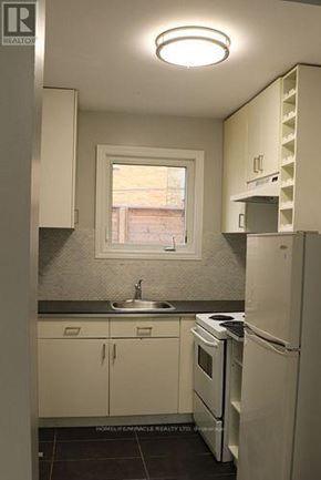 Toronto (Etobicoke West Mall) multi-family for rent - A kitchen with white appliances and cabinets.
