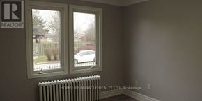 Toronto (Etobicoke West Mall) multi-family for rent - A room with a window and a radiator with a sign that says REALTOR.