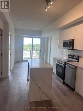 Brantford condo for rent - A modern kitchen with a marble island and stainless steel appliances.