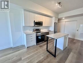 Brantford condo for rent - A kitchen with white cabinets and a black and white island.