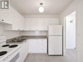 Mississauga (Applewood) condo for rent - A white kitchen with a refrigerator, sink, and stove.