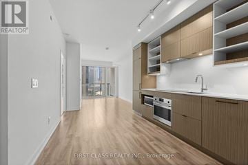 Toronto (Bay Street Corridor) condo for rent - A modern kitchen with wooden cabinets and a stainless steel oven.