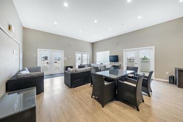 Surrey apartment for rent - A spacious living room with a black sofa set and a television.